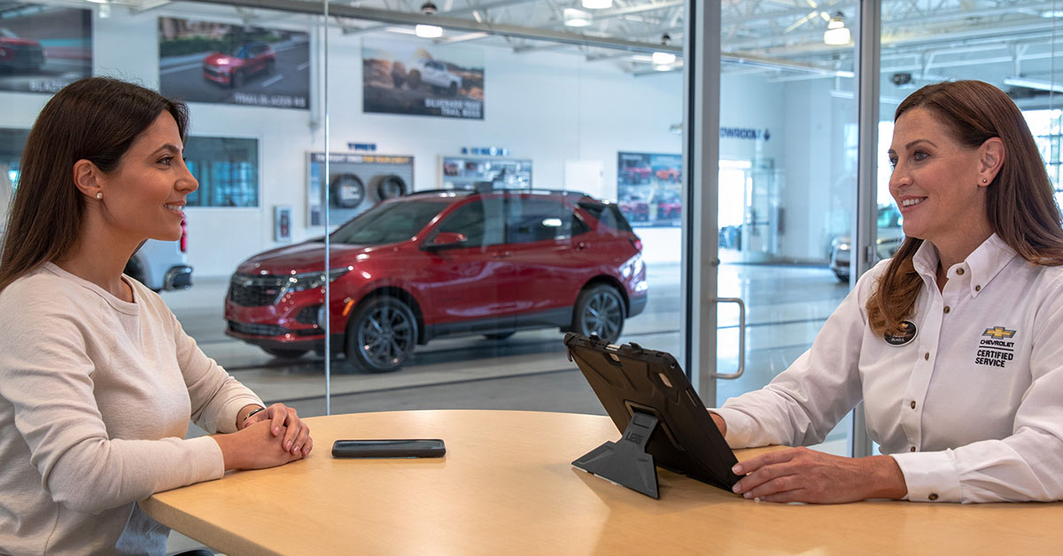 Customer speaking with salesperson at a Chevrolet dealership